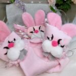 Three pink cloth rabbits with pearl eyes